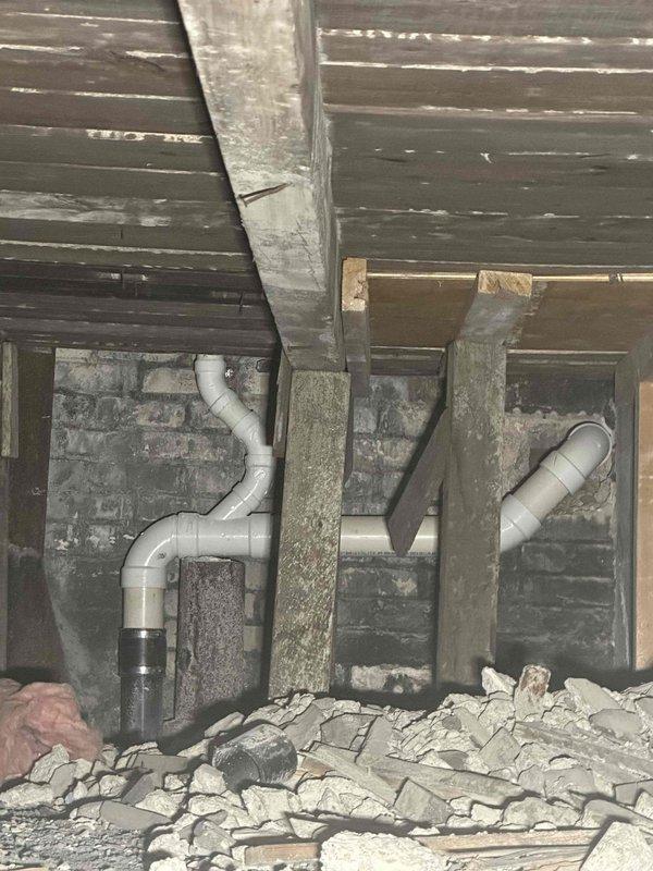 Conducted site assessment for three-compartment commercial sink installation with grease trap integration. Evaluated existing plumbing infrastructure including current drain lines, P-trap configuration, and crawl space drainage system to determine feasibility of connecting new fixtures without concrete floor penetration. Photographed and documented existing under-sink plumbing with garbage disposal, PVC drain assembly, and accessible drain lines in crawl space. Provided estimate for elevated sink and grease trap installation utilizing extended legs and mounting stand to achieve proper height differential for gravity drainage into existing waste lines, eliminating need for floor core drilling.