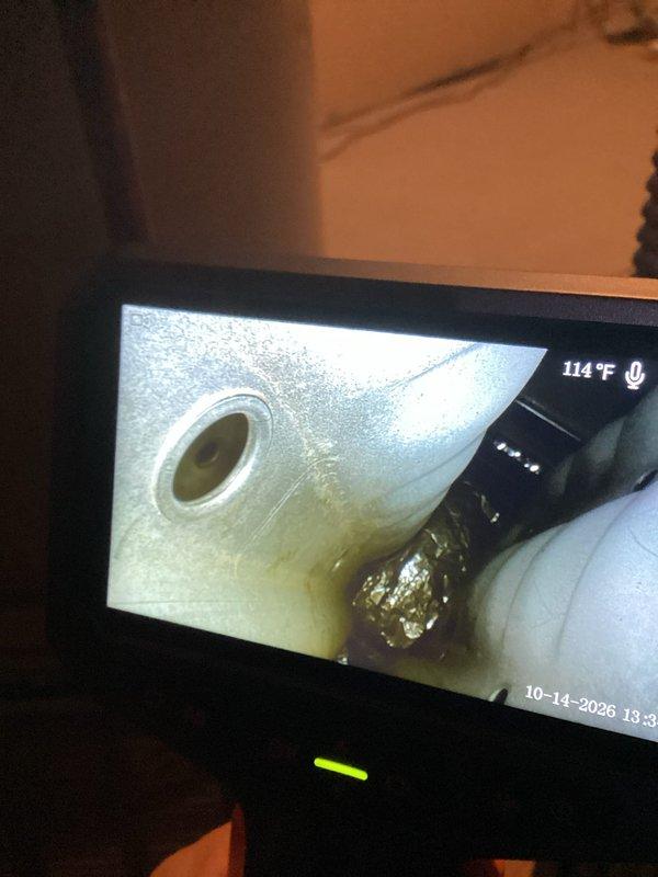Performed a planned maintenance visit on the HVAC system, including a borescope inspection of the internal ductwork and air handler cabinet. The inspection showed light surface dust and minor discoloration on the galvanized sheet metal, with crumpled foil-faced insulation or tape lodged in a seam between duct sections. System components were found in serviceable condition, and the filter and overall system status were evaluated for the next scheduled maintenance interval.