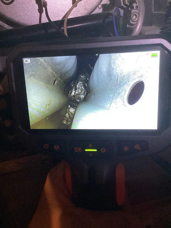 Performed a planned maintenance visit on the HVAC system, including a borescope inspection of the internal ductwork and air handler cabinet. The inspection showed light surface dust and minor discoloration on the galvanized sheet metal, with crumpled foil-faced insulation or tape lodged in a seam between duct sections. System components were found in serviceable condition, and the filter and overall system status were evaluated for the next scheduled maintenance interval.