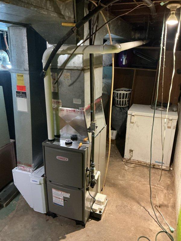 Installed a new Lennox ML196UH045XE36B high-efficiency gas furnace, connecting it to the existing sheet-metal supply plenum and trunk with foil-taped seams. Completed PVC combustion venting, black iron gas piping, condensate drain with pump, and electrical connections, and integrated an Aprilaire unit at the return side. Labeled the equipment and ductwork and left the work area clean.