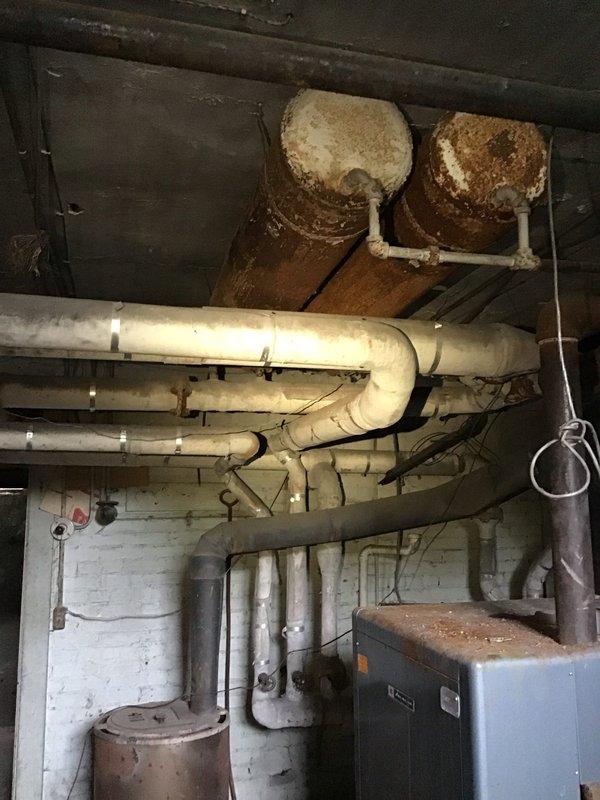 Performed an in-home evaluation for a non-operational heating system and assessed the existing boiler and distribution piping in the basement mechanical room. Documented heavy corrosion on the boiler top and upper tanks, along with aged, deteriorated pipe insulation and rusted hangers, and reviewed boiler replacement options and financing with the homeowner.