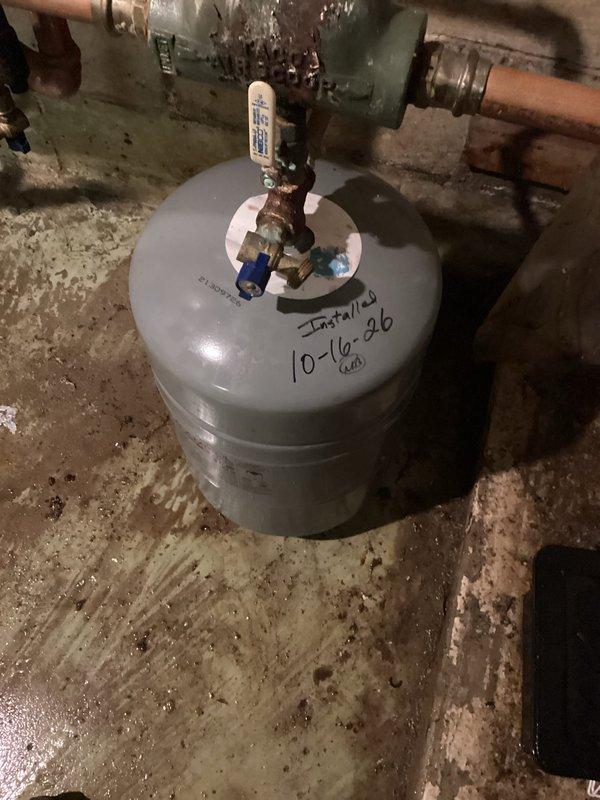 Replaced the existing expansion tank on the NTI wall-mounted boiler system with a new unit, installed upright on the hydronic loop and connected to the copper piping with a brass union and isolation valve. The installation was labeled and the system was left operational in the basement mechanical room.