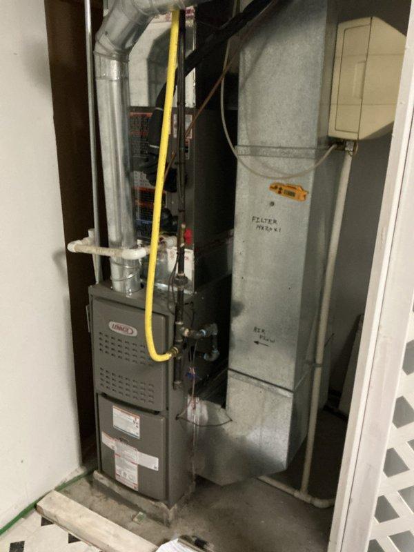 Installed a new Lennox ML180UH070E36A upflow gas furnace in the utility closet, connecting the gas supply with flexible gas line to black iron piping, the flue venting, and the PVC condensate drain. Mounted the 14x20x1 filter in the return duct with airflow direction and filter size labeled on the ductwork, and verified temperature readings at the unit with a handheld digital thermometer. Installation complete with all connections secured and no visible damage or leaks.