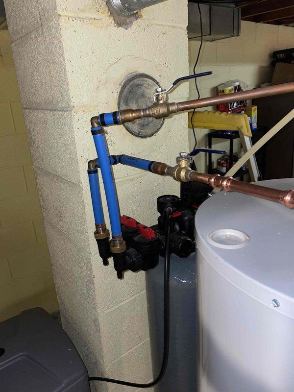 Installed the customer-supplied shower head and verified proper operation and connection integrity. Photographed the water softener assembly, including the valve head, control unit, bypass valves, and PEX/copper supply connections, to support evaluation for replacement quoting.