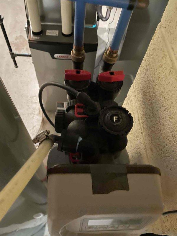 Installed the customer-supplied shower head and verified proper operation and connection integrity. Photographed the water softener assembly, including the valve head, control unit, bypass valves, and PEX/copper supply connections, to support evaluation for replacement quoting.