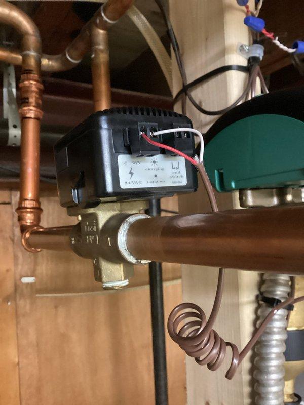 Inspected the downstairs hydronic zone valve and actuator; the 24 VAC actuator wiring and terminal connections were intact, and the copper piping and press-fit fittings showed no leaks, corrosion, or visible defects. Checked the adjacent press-fit copper connections and piping runs with a handheld diagnostic device to verify system condition and isolate the cause of the reported valve issue.