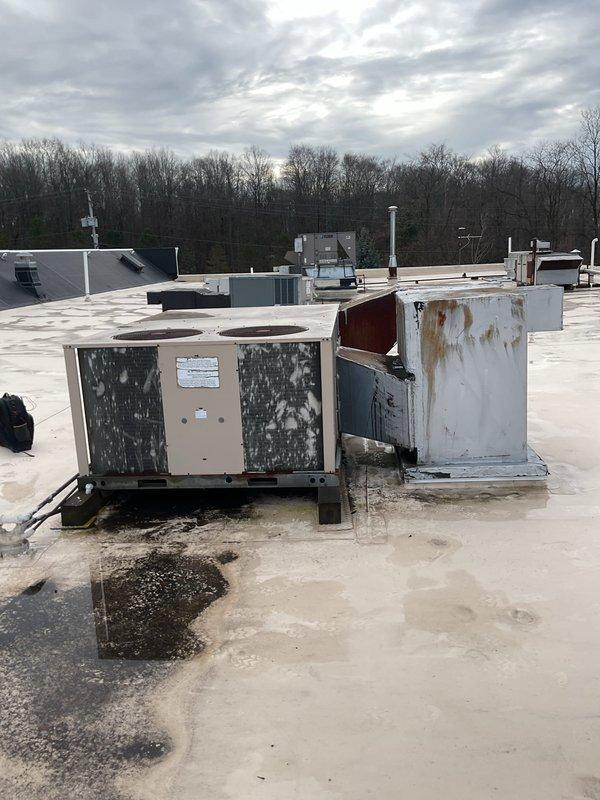 Performed scheduled commercial heating maintenance on rooftop units, documenting significant weathering and rust deterioration on both the tan and white HVAC units. Inspected blower wheel assembly and electrical wiring connections within air handler. Customer provided remaining payment for commercial maintenance agreement plan.