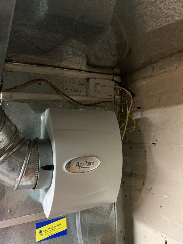 Completed warranty service call to install a humidistat for customer's Aprilaire humidifier system. Successfully mounted and connected the digital control panel with blue-lit display to the existing HVAC ductwork in basement area. System is now properly equipped with humidity control functionality as specified under original warranty terms.