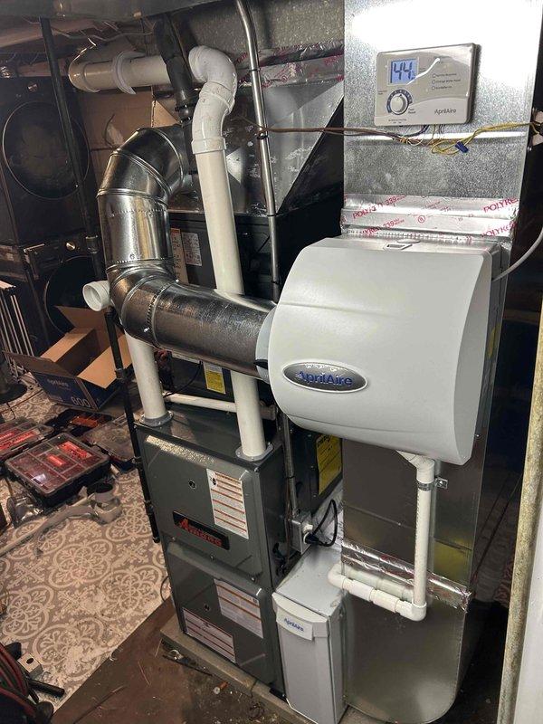 Successfully completed installation of a complete HVAC system including an Amana furnace (96% efficiency) with matching outdoor AC unit, and an Aprilaire humidifier. System was properly configured with appropriate electrical connections, insulated ductwork, and digital humidity control interface showing proper operation after installation.