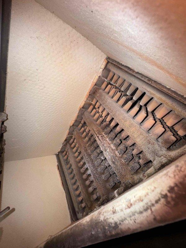 Performed routine heating system tune-up, inspecting heat exchanger coil and internal components. Discovered significant dust and debris accumulation on heating element fins and exchanger tubes, which was restricting airflow. Observed corrosion on metal components and deteriorating insulation material, which could affect system performance. Cleaned components to improve system efficiency.