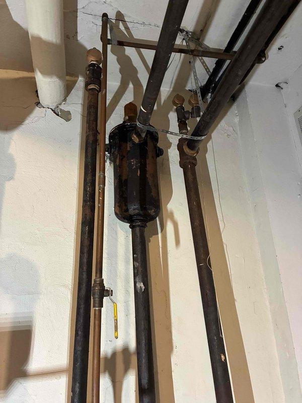 Completed scheduled boiler maintenance service. Inspected system components including pressure gauges, valves, and pipe connections. Noted significant corrosion and rust on black metal components, particularly on central valve assembly, and wall deterioration around mounting hardware. Recommended replacement of deteriorated components to prevent future system failure.