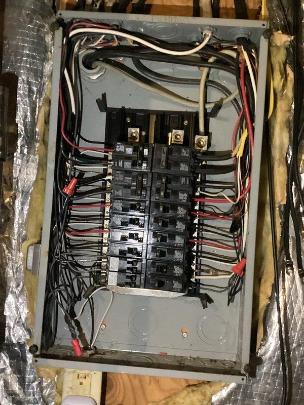 Conducted thorough electrical panel inspection revealing an aging breaker panel with densely packed wiring. Observed proper wire connections but noted potential organization issues with multiple black, red, and white wires. Documented panel condition including circuit breaker functionality for client reference.
