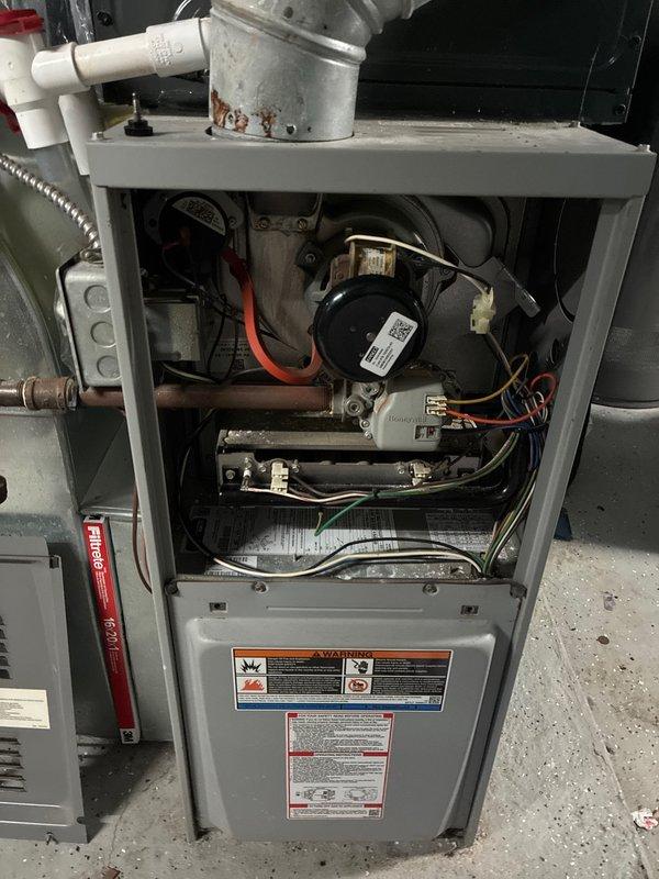 Responded to no-heat call for 12-13 year old furnace. Inspected unit, removed front panel to examine internal components including blower motor, electrical connections, and gas line system. Observed normal wear including rust on flue pipe. Discussed replacement options with customer who was considering obtaining additional quotes after previous repair work.