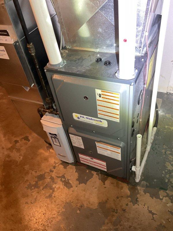 Responded to customer complaint of heating system producing only lukewarm air. Upon inspection of P.K. Wadsworth furnace, found issues with blower motor assembly affecting proper heat distribution. Serviced internal electrical components and gas valve assembly to restore normal operation. System now producing adequate heat with proper airflow.