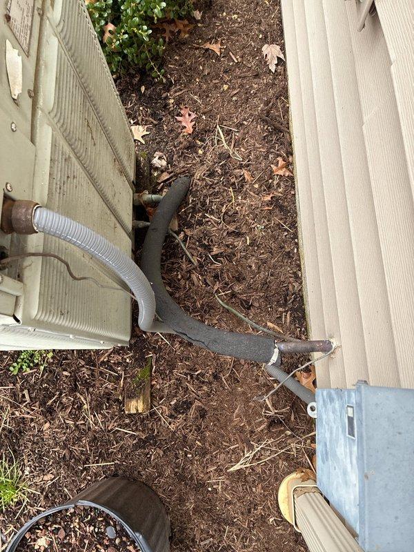 Completed AC unit replacement with accessible installation location. New exterior condenser unit was properly positioned with condensate line connection. Interior work included connecting to existing ductwork and plenum chamber within the wooden structural framing. System installation verified with all connections secure.