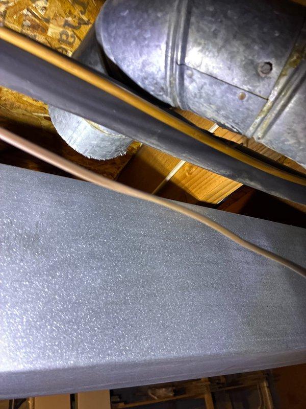 Completed AC unit replacement with accessible installation location. New exterior condenser unit was properly positioned with condensate line connection. Interior work included connecting to existing ductwork and plenum chamber within the wooden structural framing. System installation verified with all connections secure.