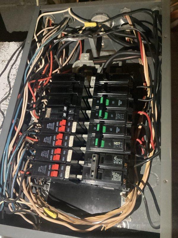 Conducted assessment for customer's light fixture replacement needs and evaluated non-functioning dryer breaker issue. Inspection revealed outdated electrical panel with disorganized wiring configuration and potentially problematic circuit breakers. Documented current plumbing installation with pressure regulator valve and multiple pipe connections for reference during electrical work planning.