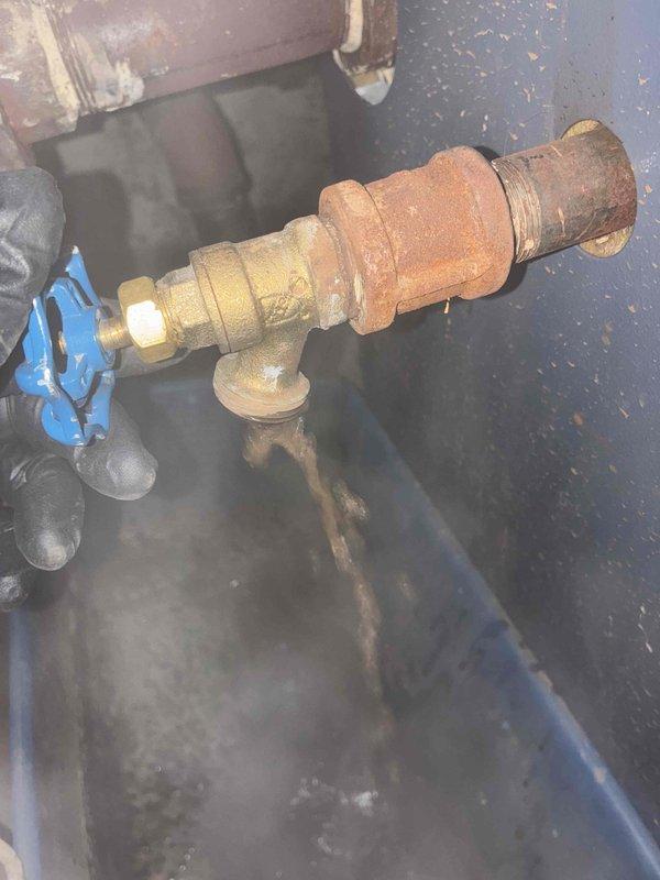 Performed routine boiler maintenance including combustion analysis with gas analyzer showing readings of 127/46.3. Inspection revealed significant corrosion and oxidation on brass pipe fittings, particularly at valve assembly with blue handle. Noted moisture accumulation in enclosure that requires monitoring.