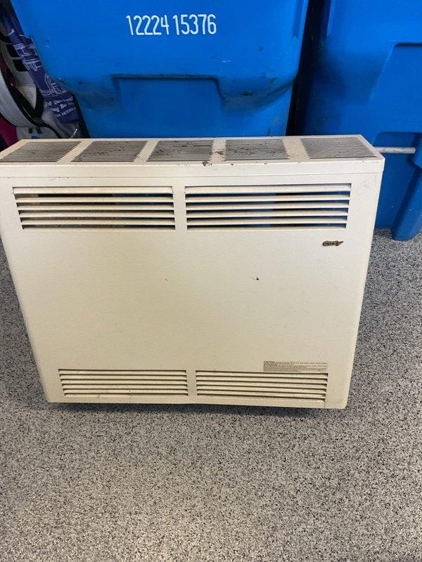 Diagnosed non-operational garage heater unit. Inspected wall-mounted convection heater showing signs of age and wear. System appears to be installed in a garage space used for bicycle storage. Recommended replacement options due to unit's condition and inefficient operation.