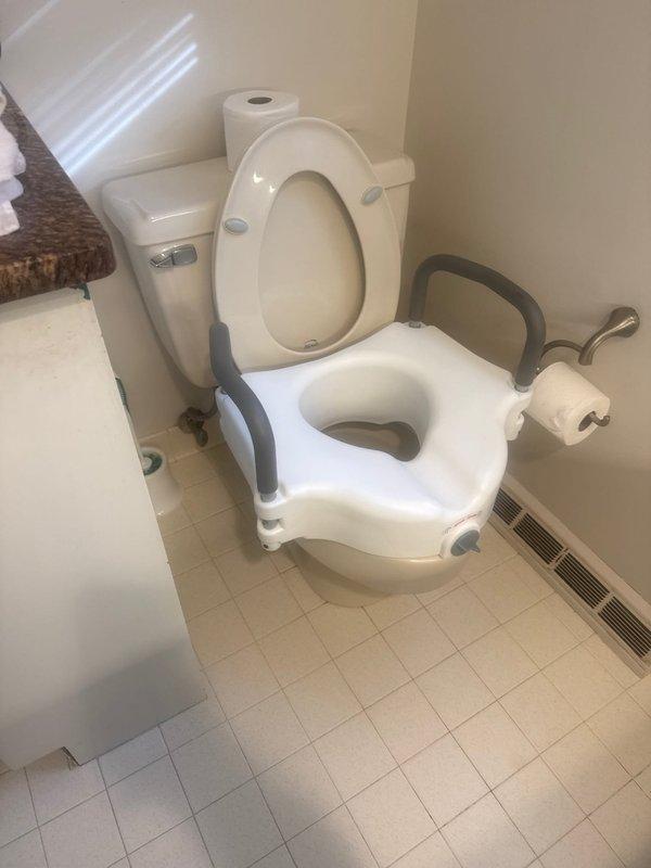 Performed maintenance inspection of water heater system and identified expansion tank requiring replacement. Assessed bathroom plumbing fixtures including toilet with assistive seat. Noted PVC drainage pipe with 90-degree elbow joint showing signs of deterioration at wall connection point with visible white residue. Recommended professional plumbing service for expansion tank replacement.