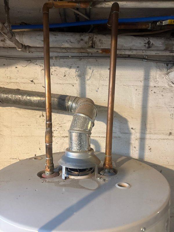 Performed scheduled maintenance on GE tanked water heater located in basement. Inspected all connections including copper supply lines, drain valve with attached hose, and metal ventilation ductwork. Confirmed proper installation and functionality of unit with no immediate issues requiring repair.