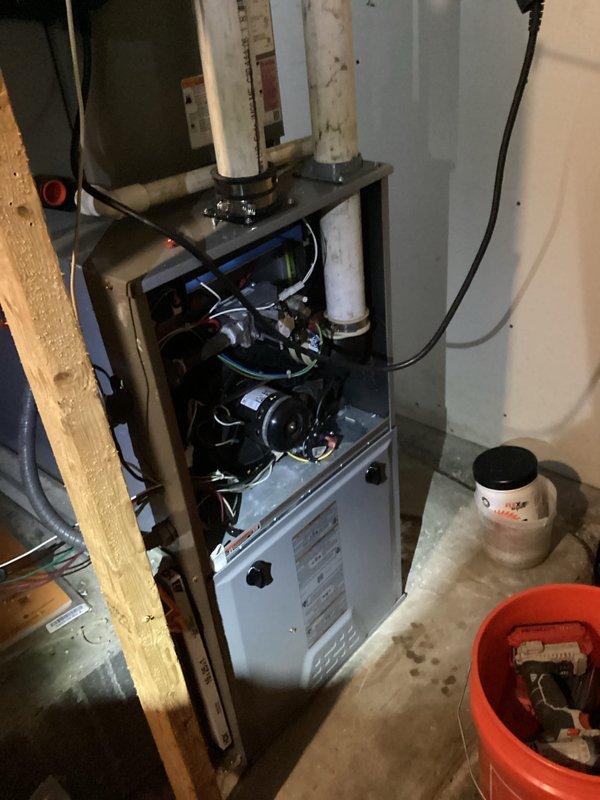 Performed routine heating maintenance on residential furnace system. Conducted combustion analysis using Testo 310 analyzer, recording CO2 levels at 10.25% and O2 at 9.0%. Inspected internal components with access panel open and verified proper venting through PVC exhaust system.