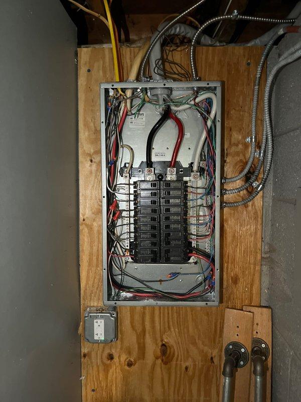 Installed new 120V circuit connecting from main panel to junction box. Work included running electrical conduit through basement ceiling joists and terminating connections at breaker panel. Proper circuit was established with appropriate wire colors (black, white, red, green) maintaining code-compliant organization within the panel.