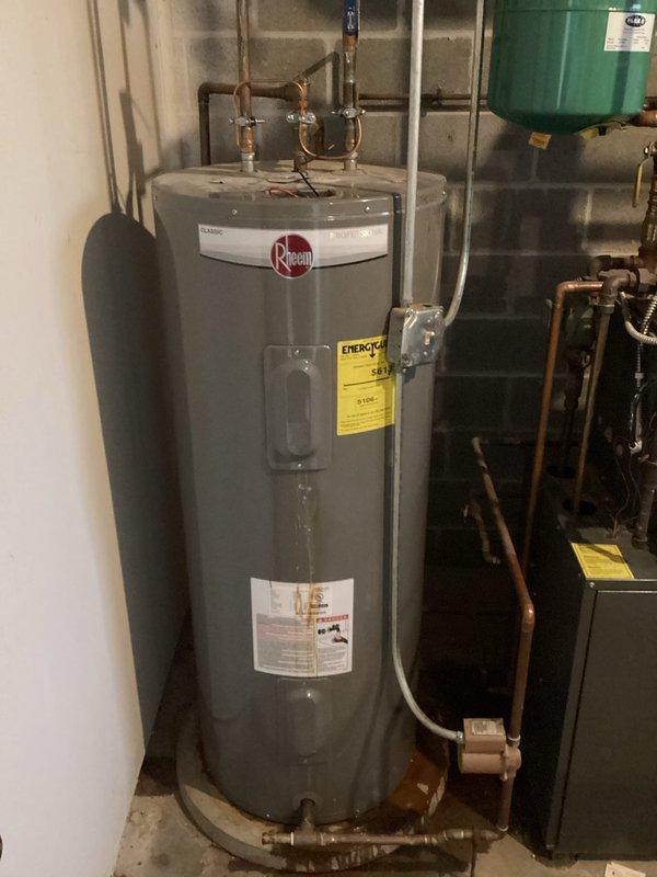 Conducted comprehensive inspection of existing Rheem water heater installation in utility room. System includes copper piping connections, expansion tank mounted on concrete block wall, and integration with adjacent HVAC equipment. Customer seeking estimate for complete water heater replacement. Current unit appears functional with no visible leaks or damage.
