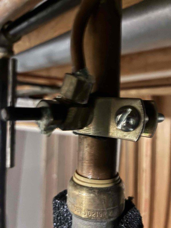 Responded to active humidifier leak. Inspected HVAC system and identified water discharge from humidifier unit onto basement floor. Upon examination, discovered damaged mounting bracket on copper feed line which was causing improper connection and subsequent water leakage. Repaired securing bracket and verified proper operation with no further leakage.