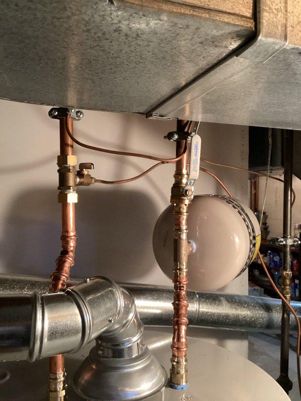 Installed new 50-gallon Bradford White short water heater with complete code-compliant upgrades. System includes properly mounted expansion tank, new copper supply lines with brass fittings, and updated ventilation components. All connections were tested and verified to be functioning correctly.