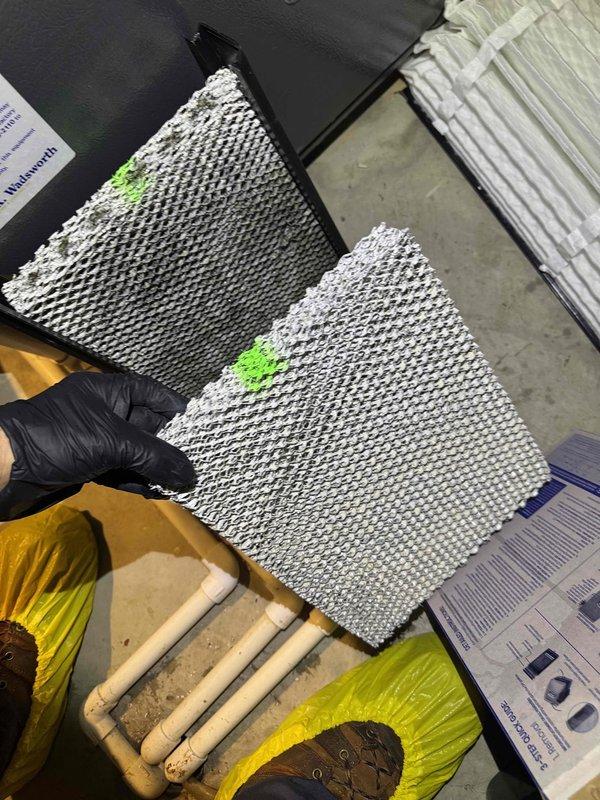 Performed routine heating maintenance on an aging furnace system. Removed and inspected heavily soiled air filters with significant dust accumulation, noting the need for replacement. System appears to be functioning with proper ventilation and condensate drainage despite age.