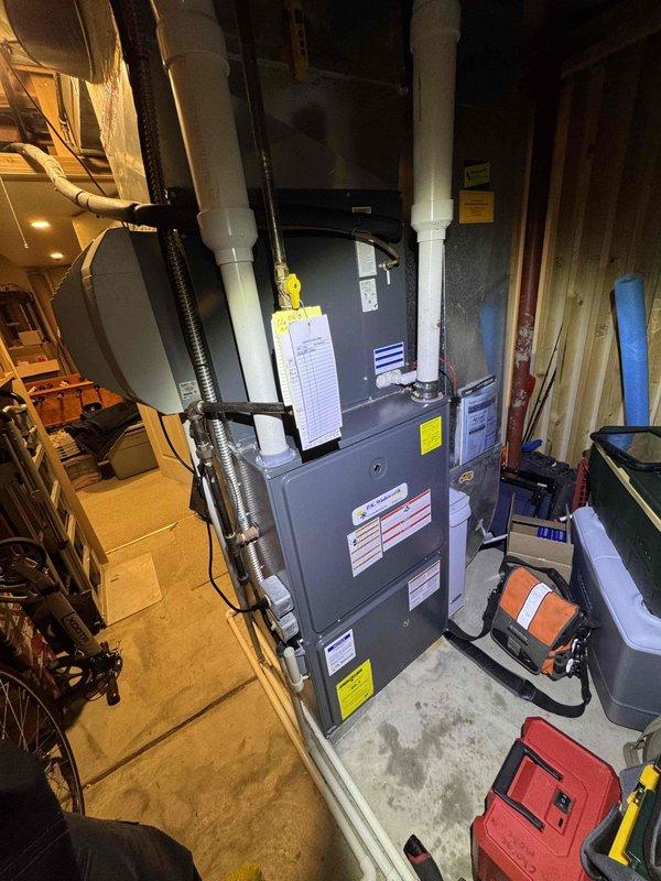 Performed routine heating maintenance on an aging furnace system. Removed and inspected heavily soiled air filters with significant dust accumulation, noting the need for replacement. System appears to be functioning with proper ventilation and condensate drainage despite age.