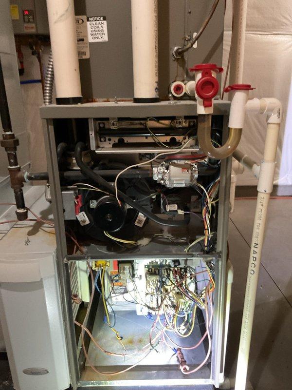 Performed comprehensive maintenance on residential furnace system in unfinished basement. Opened access panel to inspect internal components including blower motor, electrical connections, control board, and PVC condensate drainage system. Verified proper operation of red valve assembly and examined all electrical wiring and connections for safety and functionality.
