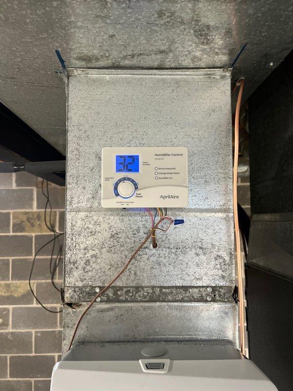 Completed installation of a complete HVAC system including an 80% efficiency furnace, air conditioning unit, AprilAire humidifier with digital control panel (set at 25% humidity), and liner. System was properly mounted on concrete pad with all necessary ductwork, PVC venting, and electrical connections installed according to manufacturer specifications.