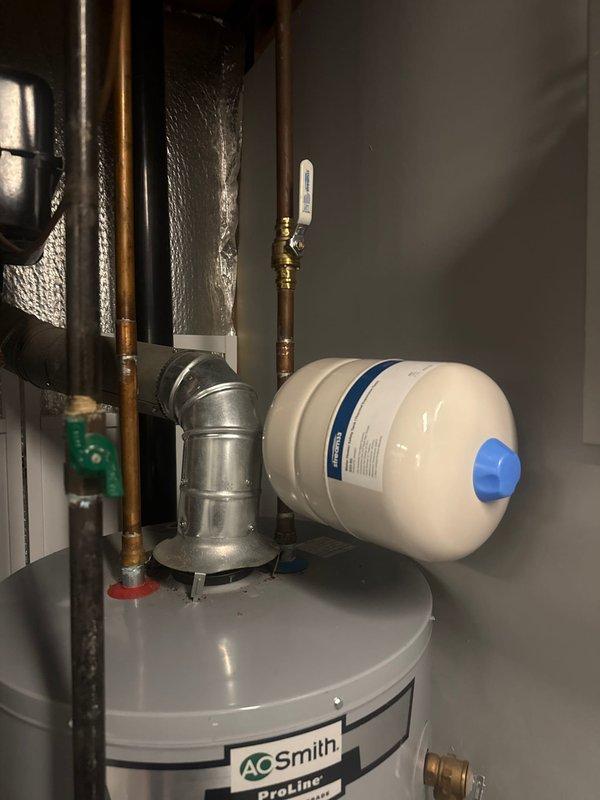 Installed new expansion tank and shut-off valve on customer's A.O. Smith ProLine water heater system. Properly connected components using copper piping and brass fittings, ensuring all connections were securely soldered and leak-free.
