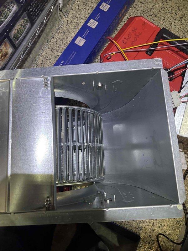 Responded to customer complaint of loud clicking noise from furnace. Upon inspection, discovered accumulated debris and cobwebs in the blower assembly. Removed, cleaned, and serviced the squirrel cage fan unit and motor components. Checked all electrical connections including yellow and pink wiring to ensure proper contact. Reinstalled blower assembly and verified normal operation with no further noise issues.