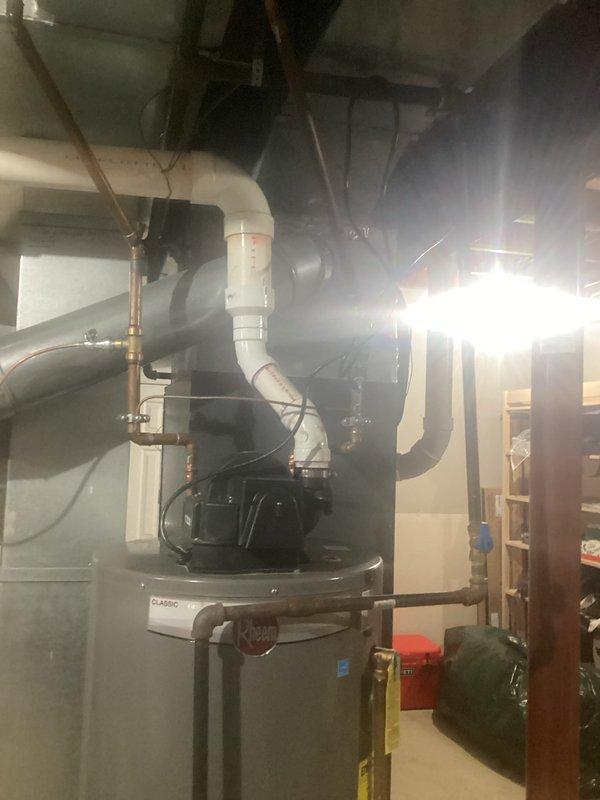 Conducted electrical inspection of residential panel system. Examined outlet installation on cinder block wall with conduit routing and verified proper grounding. Inspected adjacent HVAC system including Rheem unit and associated electrical connections.