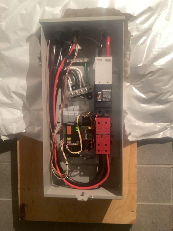 Performed comprehensive electrical panel inspection, documenting circuit breaker conditions and wire connections. Noted exposed bus bars and extensive wiring configuration in the main panel mounted on wooden backing. Verified proper terminal connections and identified red/black wire routing through the system.