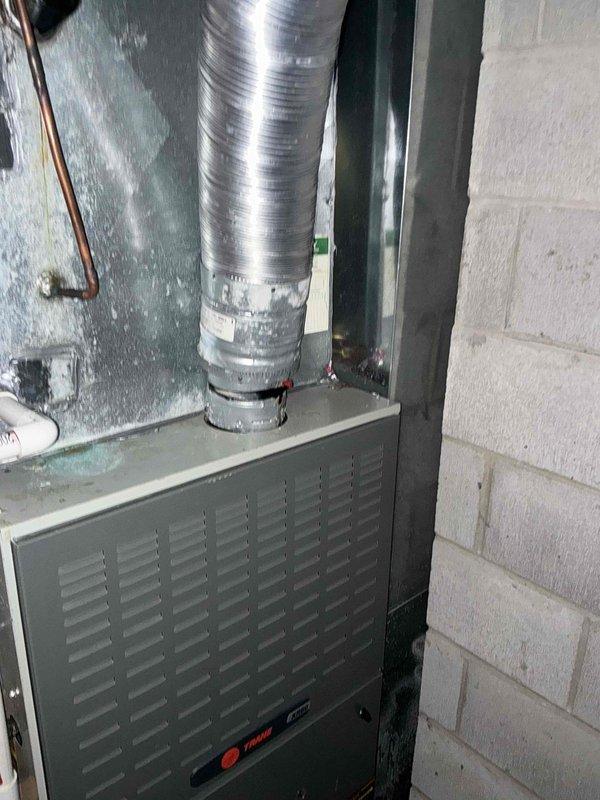 Conducted assessment of older Trane furnace system in basement utility room. Unit still operational with good heat output but showing signs of age-related wear. Noted favorable installation conditions with easy access for replacement. Documented existing setup including furnace, ductwork configuration, and connection points to assist with replacement options.