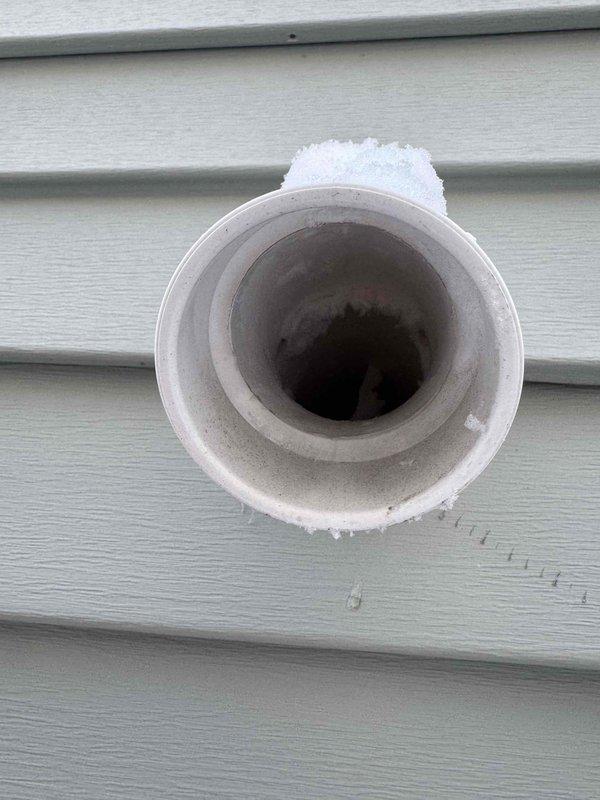 Diagnosed and serviced 2009 Bryant heating system experiencing no heat condition. Inspection revealed motor/blower assembly issues and significant frost accumulation on the external PVC exhaust vent pipe indicating possible condensate drainage problems. Cleaned components, restored proper operation by addressing ventilation blockage and ensuring proper system function.