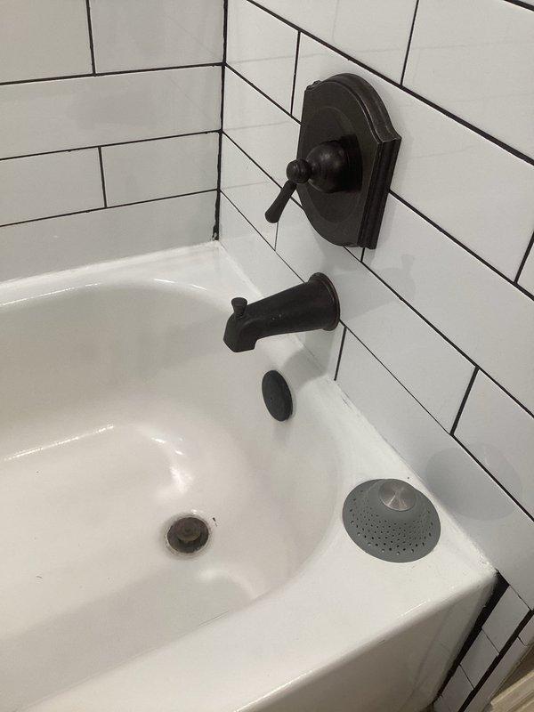 Performed water heater maintenance and inspected slow draining bathroom fixtures. Diagnosed diverter valve issue causing improper water flow transition between bath spout and shower function. Recommended service for both the drainage system and diverter valve mechanism to restore proper functionality.