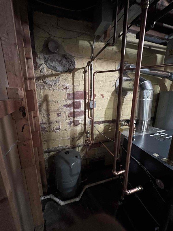 Completed installation of a GVD-8 boiler system in basement utility area. Installed new copper supply/return lines with proper connections to existing plumbing network. Mounted expansion tank and connected vent piping according to manufacturer specifications.