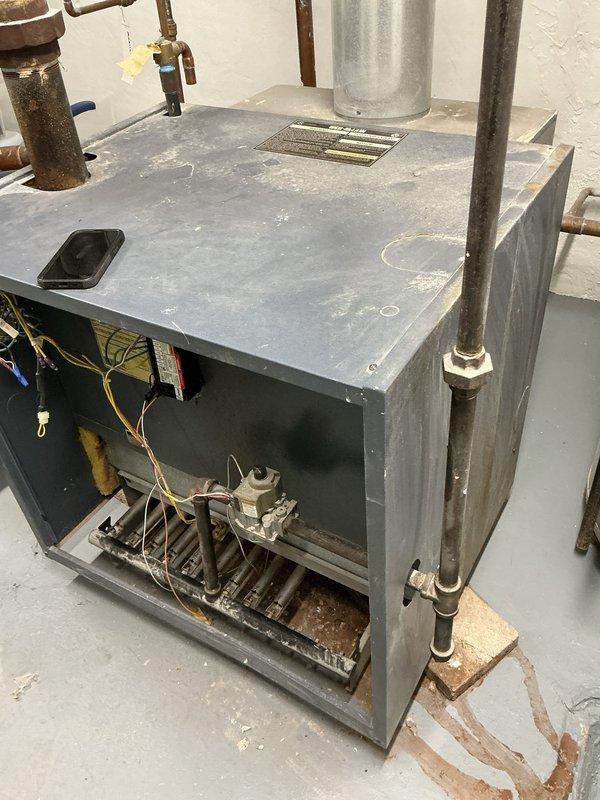 Performed routine maintenance on 24-year-old boiler system. Identified significant crack in boiler base causing active leakage. Documented condition with detailed photos showing internal components and evidence of water damage. Recommended full replacement of unit due to age and structural failure.