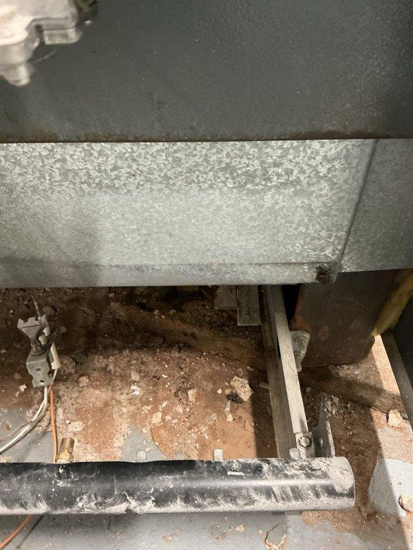 Performed routine maintenance on 24-year-old boiler system. Identified significant crack in boiler base causing active leakage. Documented condition with detailed photos showing internal components and evidence of water damage. Recommended full replacement of unit due to age and structural failure.