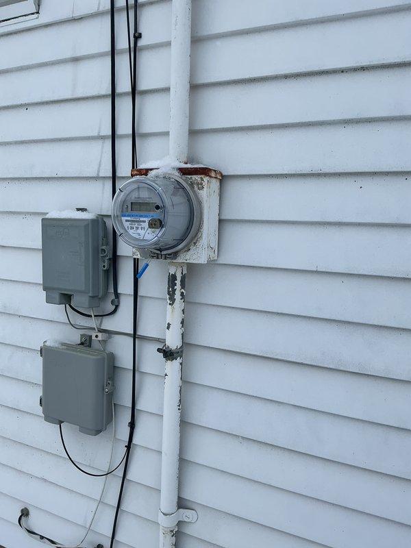 Performed electrical inspection of residential service entrance components. Noted visible corrosion at meter base mounting points where attached to exterior siding. Panel and breakers appear functional despite weathering at connection points.