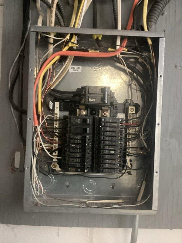 Conducted comprehensive inspection of residential electrical panel following home inspector's concerns. Panel features a main breaker with multiple circuit breakers arranged in two vertical rows, showing signs of crowded wiring with various gauge conductors. Assessment included evaluation of breaker functionality, wiring connections, and overall panel condition to determine if replacement is necessary per inspection report findings.