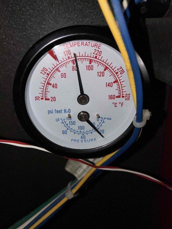 Conducted follow-up service on persistently malfunctioning boiler, representing fifth service call for ongoing issues. Inspected temperature/pressure gauge readings (80°F/50-60 psi) and examined condensate handling system including drainage hoses and catch container. Performed system adjustments to restore proper operation.