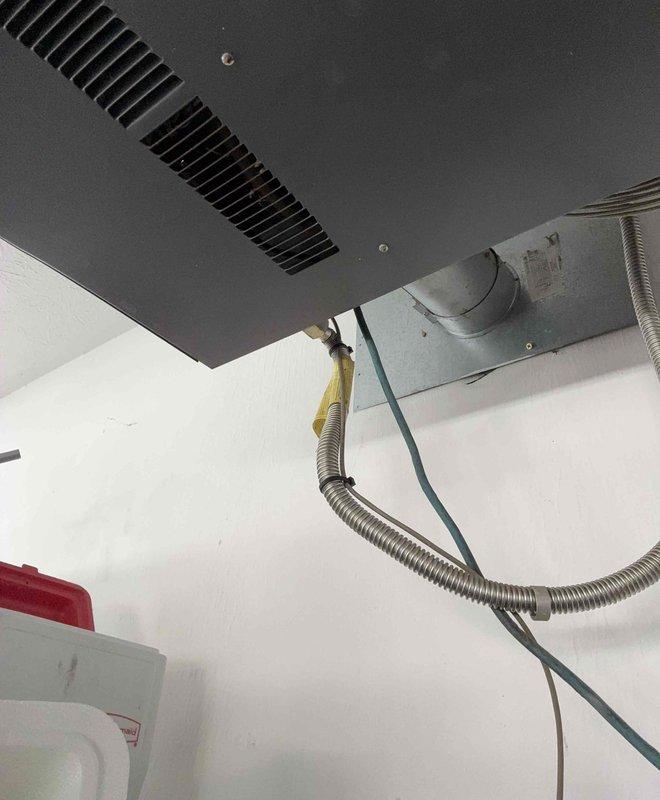 Conducted inspection and provided quote for garage heater replacement. Current installation shows aging unit with flexible metal ductwork connected to ceiling-mounted register. Noted textured ceiling condition and existing ventilation configuration for proper replacement specifications.