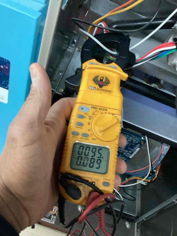 Performed routine heating maintenance on residential HVAC system. Conducted electrical diagnostic testing with clamp meter, measuring amp draw readings of 0.095 and 0.089 on the furnace components. Inspected control board, wiring harnesses, and ventilation system with access panel open to verify proper operation.