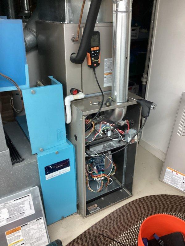 Performed routine heating maintenance on residential HVAC system. Conducted electrical diagnostic testing with clamp meter, measuring amp draw readings of 0.095 and 0.089 on the furnace components. Inspected control board, wiring harnesses, and ventilation system with access panel open to verify proper operation.